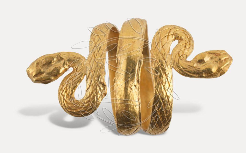 Χρυσό δακτυλίδι από περιελισσόμενο έλασμα, που στα δύο άκρα απολήγει σε κεφαλές φιδιών. Φισκάρδο. Ναόσχημος ταφικός θάλαμος στη θέση Τηγάνια. 2ος – 3ος αι. μ.Χ.