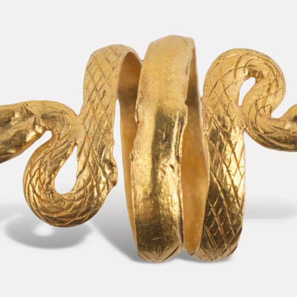 Χρυσό δακτυλίδι από περιελισσόμενο έλασμα, που στα δύο άκρα απολήγει σε κεφαλές φιδιών. Φισκάρδο. Ναόσχημος ταφικός θάλαμος στη θέση Τηγάνια. 2ος – 3ος αι. μ.Χ.