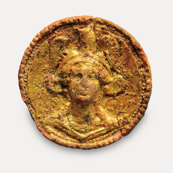 Terracotta gilded button with a head of Athena Parthenos. Same. South cemetery. Late 4th century BC
