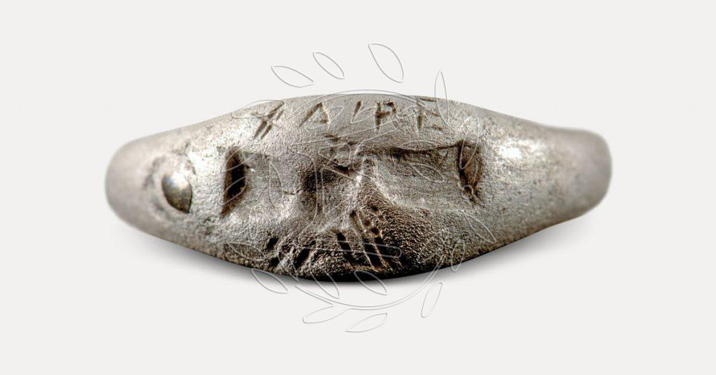 Αργυρό δακτυλίδι με έγγλυφη παράσταση χειραψίας και την επιγραφή ΧΑΙΡΕ με την οποία αποχαιρετάται ο θανών. Σάμη. Τέλος 4ου αι. π.Χ.