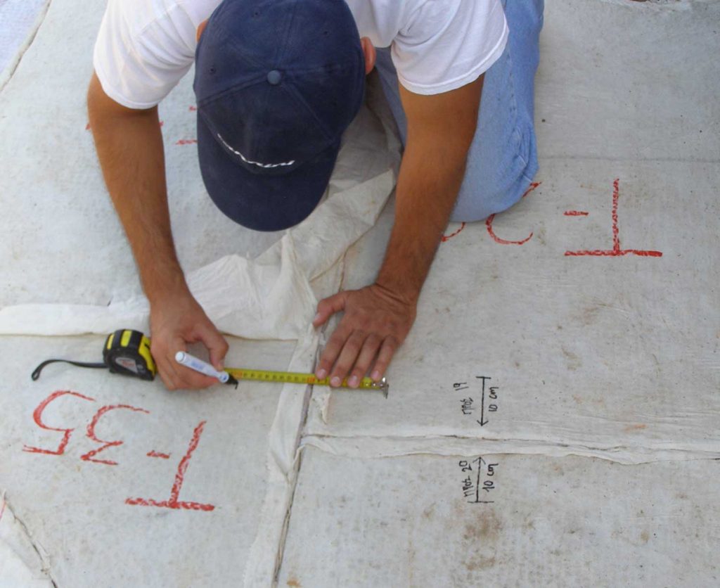 Counting and noting distances between pieces of the mosaic floor in the Bath installation in Dimoula plot, before being detached. 2006